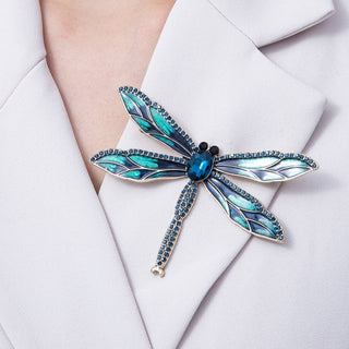 Blue dragonfly-shaped brooch on a white blazer