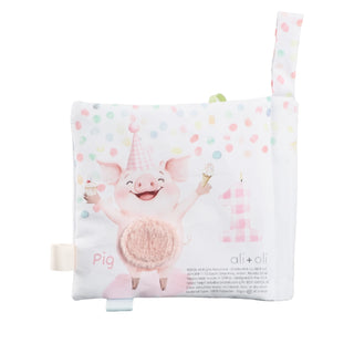 Children's soft book with a cartoon pig character on a white background