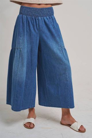 Blue denim wide-leg pants worn by a person on a plain background