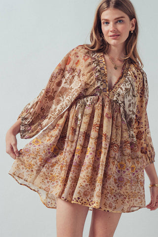 Woman wearing a floral dress against a plain background
