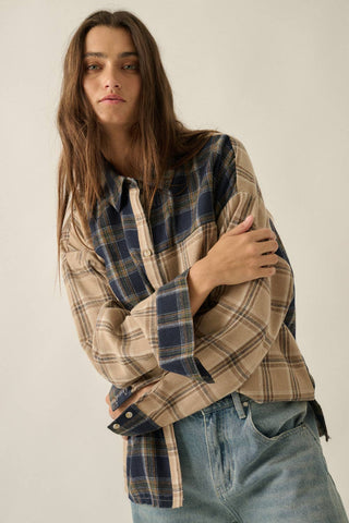 Person wearing a plaid shirt and jeans against a plain background