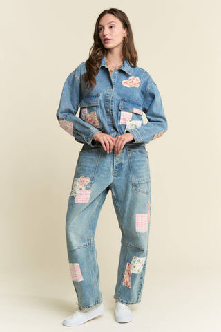 Woman wearing a denim outfit with patches on a beige background