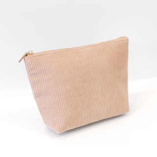 A light beige corduroy zipper pouch with a gold-tone zipper, photographed on a clean white background.