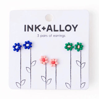 Packaged earrings with 'INK+ALLOY' branding on a white background