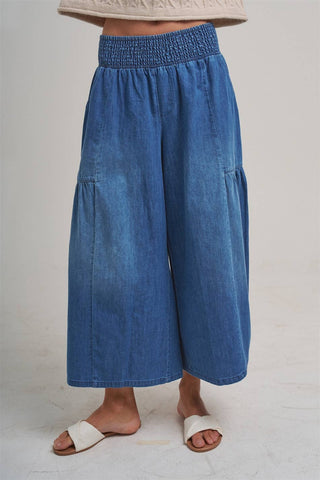 Blue denim wide-leg pants worn by a person on a plain background