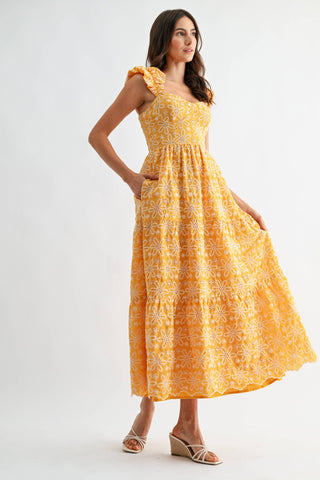 Woman wearing a yellow floral dress on a white background