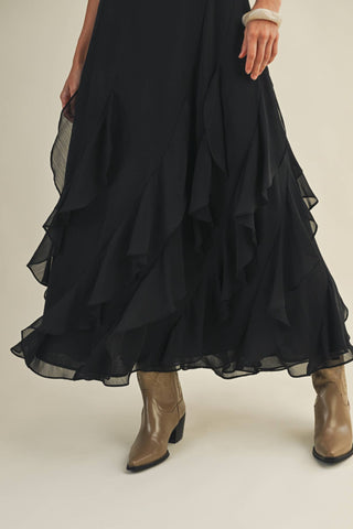 Black layered skirt with beige boots on a neutral background