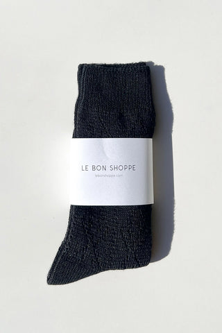 Pair of dark gray socks with a white label on a light gray background