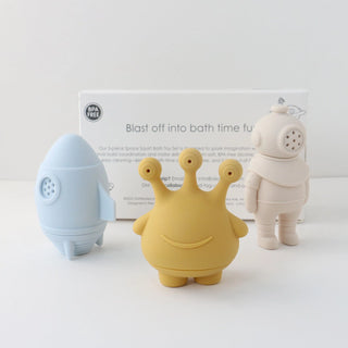 Three colorful bath toys on a white background with a product box in the background.