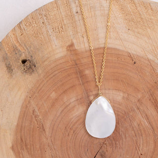Necklace with a teardrop-shaped pendant on a wooden surface
