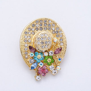 Decorative brooch with colorful gemstones on a light gray background