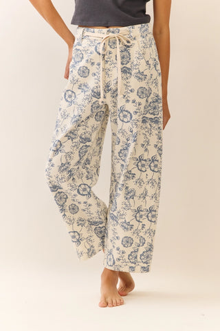 Person wearing floral pajama pants on a plain background