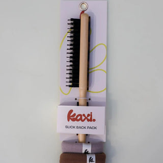 Kaxi slick back pack with comb and hair products on a white background