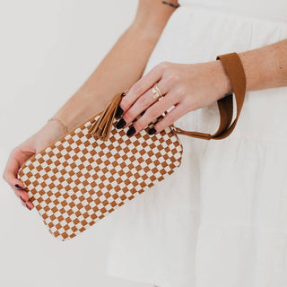 Person holding a woven clutch bag with a checkered pattern on a white background