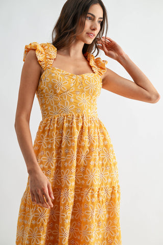 Woman wearing a yellow floral dress on a white background