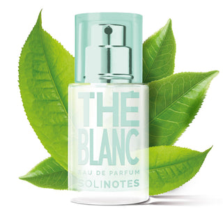 Perfume bottle labeled 'The Blanc' with green leaves on a white background