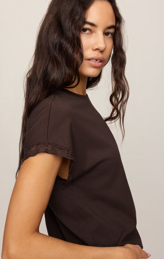 Woman wearing a black t-shirt against a plain background