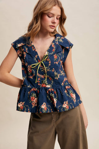 Woman wearing a floral peplum top with a plain background