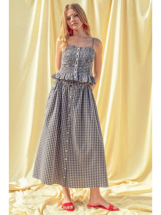 Woman wearing a black and white checkered dress with a yellow curtain background
