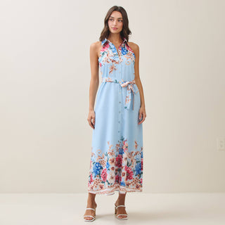 Woman wearing a light blue floral dress on a plain background