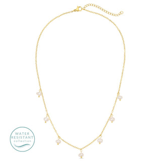 Gold necklace with pearls on a white background, featuring a water-resistant logo.