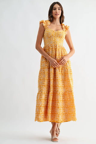 Woman wearing a yellow floral dress on a white background