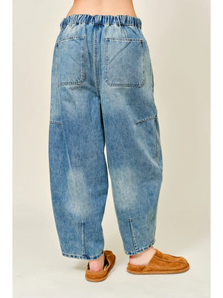 Blue jeans worn by a person on a beige background