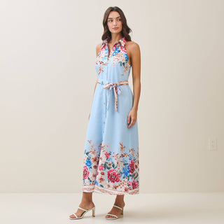 Woman wearing a light blue floral dress against a plain background