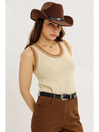 Woman wearing a cowboy hat and beige sweater tank top
