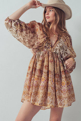 Woman wearing a floral dress and beige hat against a plain background