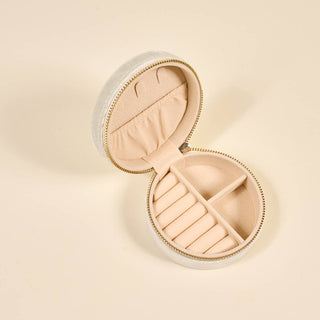 Round jewelry box with a beige interior on a beige background