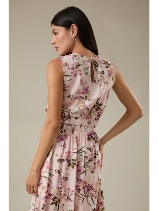 Woman wearing a floral dress against a neutral background