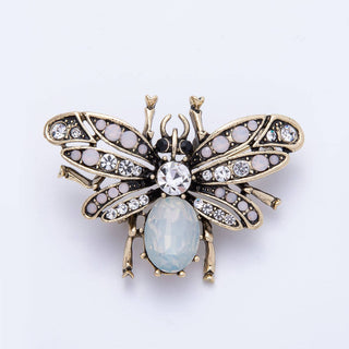 Decorative bee brooch with gemstones on a white background