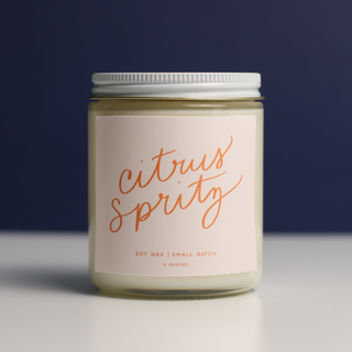 Candle jar labeled 'citrus spritz' on a dark background