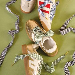 Pair of sandals with checkered ribbons on a green background