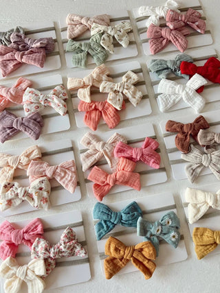 Collection of colorful fabric bows arranged on a white surface