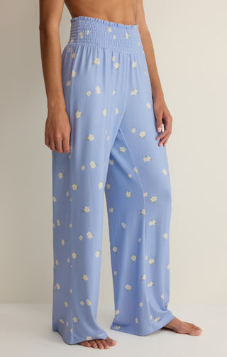 Light blue pants with white floral pattern worn by a person on a neutral background