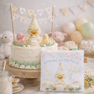 Birthday cake with duck character and matching book on a table with balloons and decorations.