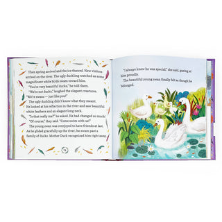 Open book with illustrations of swans and a colorful landscape