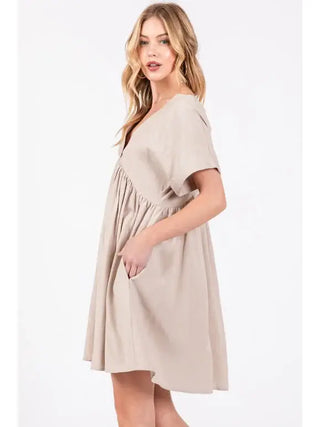 Woman wearing a beige dress on a white background