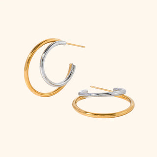 Pair of gold and silver hoop earrings on a white background