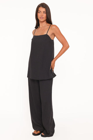 Woman wearing a black patterned pajama set on a white background