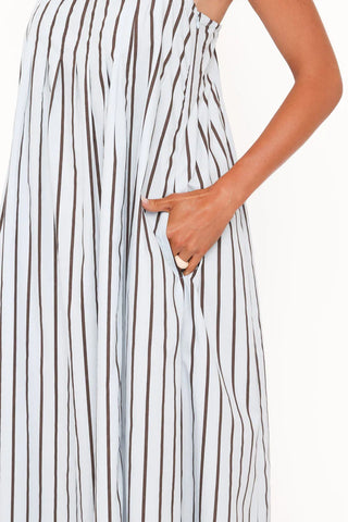 Close-up of a sleeveless white dress with vertical brown stripes and a side pocket, shown on a model against a plain white background.
