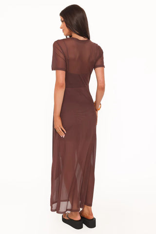 Woman wearing a brown dress with sheer panels on a white background