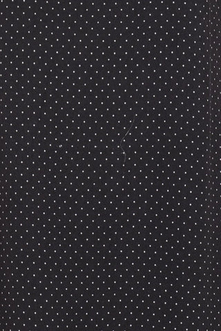 A close-up of a black fabric with a small white polka dot pattern.