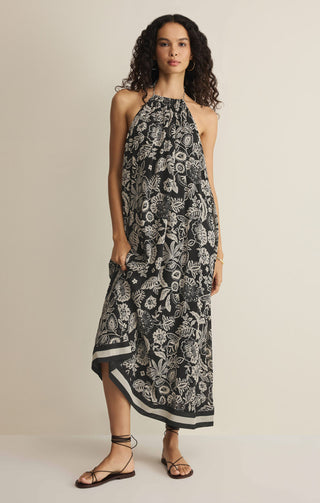 Woman wearing a black floral halter dress on a beige background