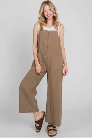 Woman wearing a brown jumpsuit on a white background