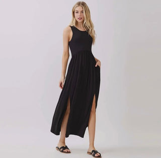 Woman wearing a black sleeveless dress with a slit on a white background