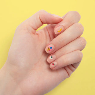 Hand with colorful nail art on a yellow background