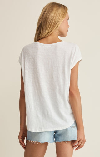Woman wearing a white t-shirt and denim shorts on a beige background
